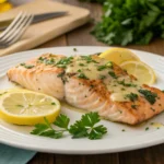 A beautifully baked Garlic Butter Salmon garnished with fresh parsley and lemon wedges, served on a white plate for a perfect dinner.